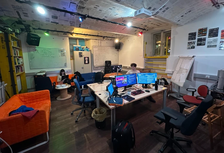 The library with computer screens, projector and two people working on computers